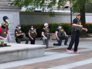 Large group of FBI agents (25) take a knee with protestors near the national archive.